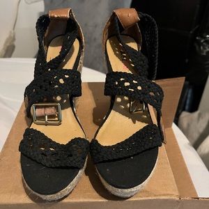 Black espadrille with knitted straps with buckle.